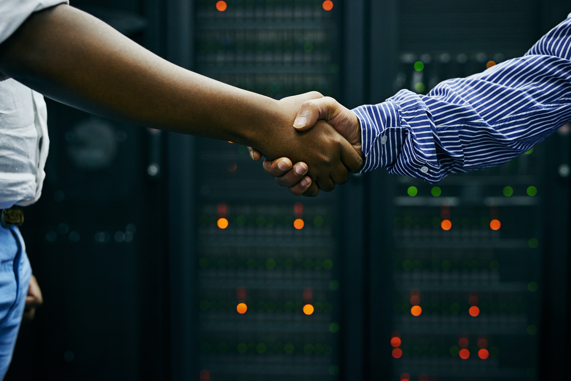 paired up for professional it service cropped shot of two men shaking hands in a data center